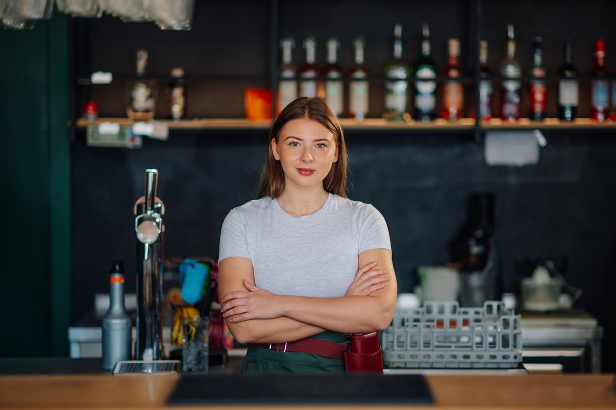 Empresaria latina en su pequeño negocio sonriendo con confianza