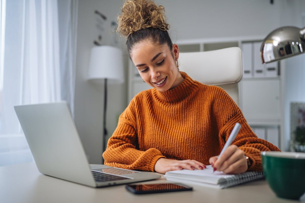 Mujer emprendedora revisando información organizada en su computadora, en un ambiente de oficina tranquilo
